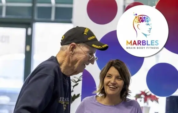Trainer talking with veteran at Marbles Fitness